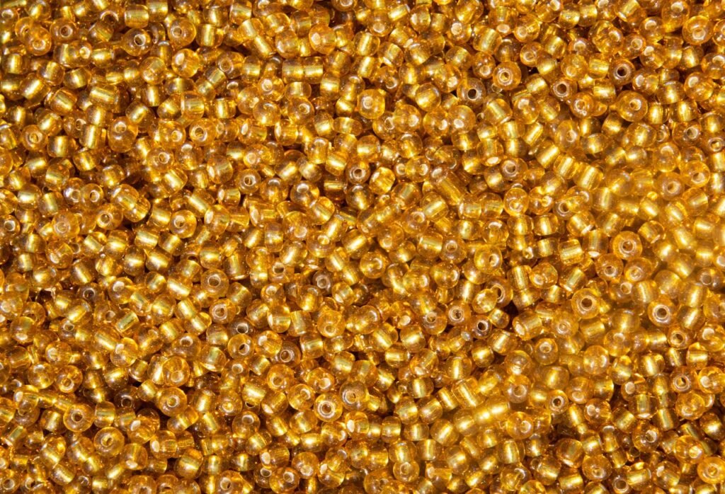 Close-up of vibrant gold beads creating a shimmering texture, ideal for backgrounds and crafts.